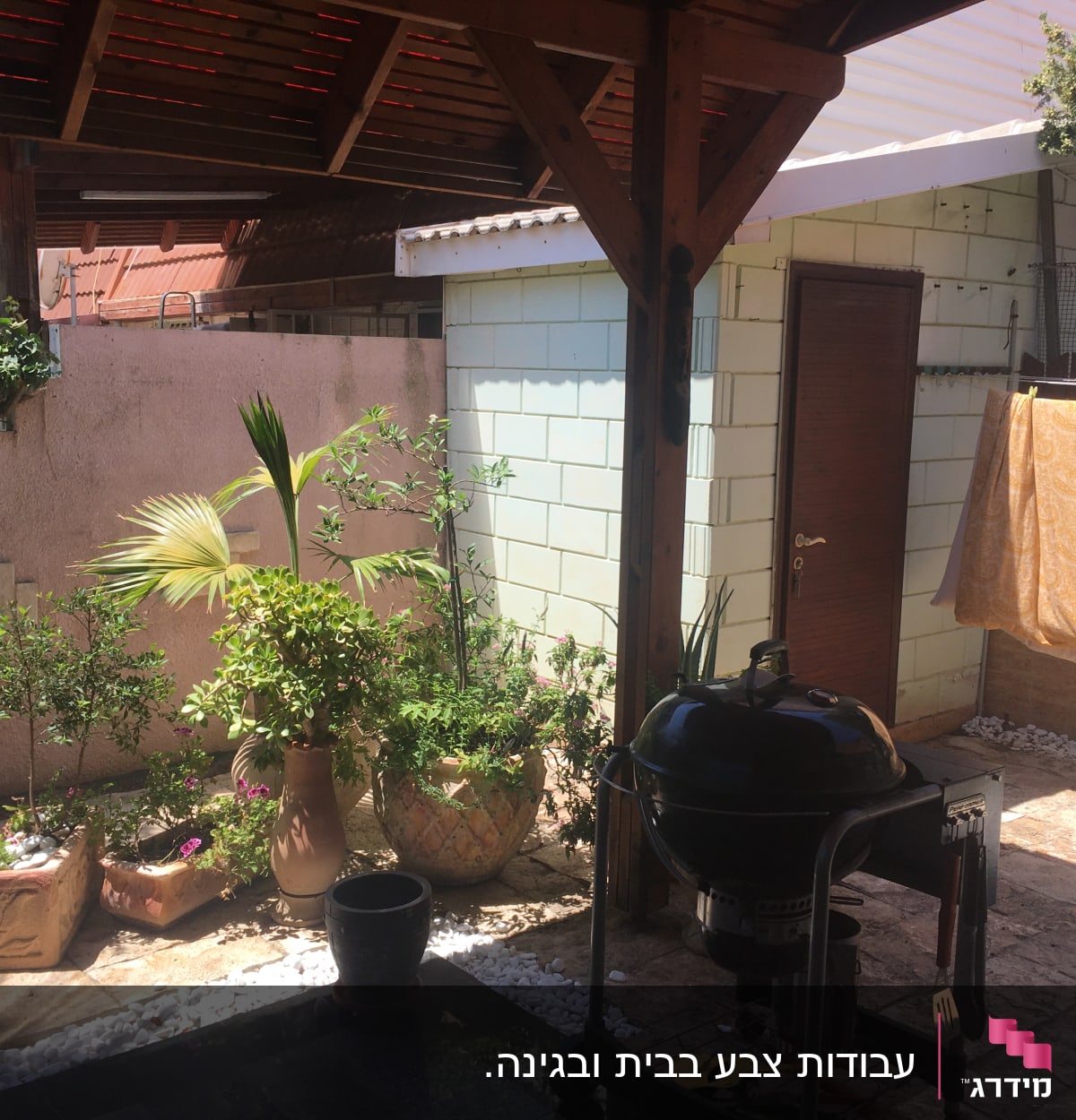 חצר עם עציצים, גריל ומתקן כביסה